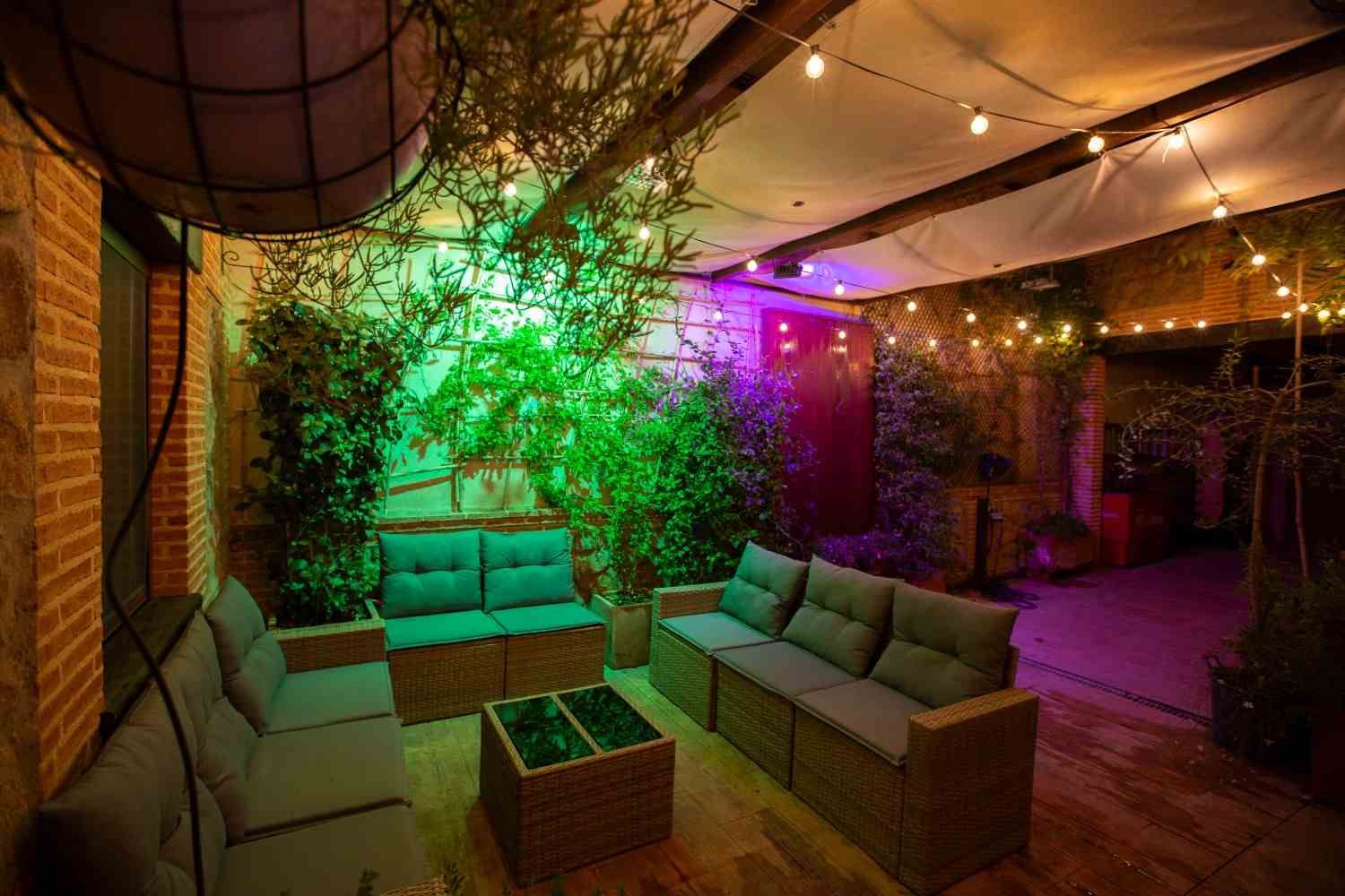 Acogedor dormitorio rústico con vigas de madera, una cama blanca con manta verde y cálida luz natural.