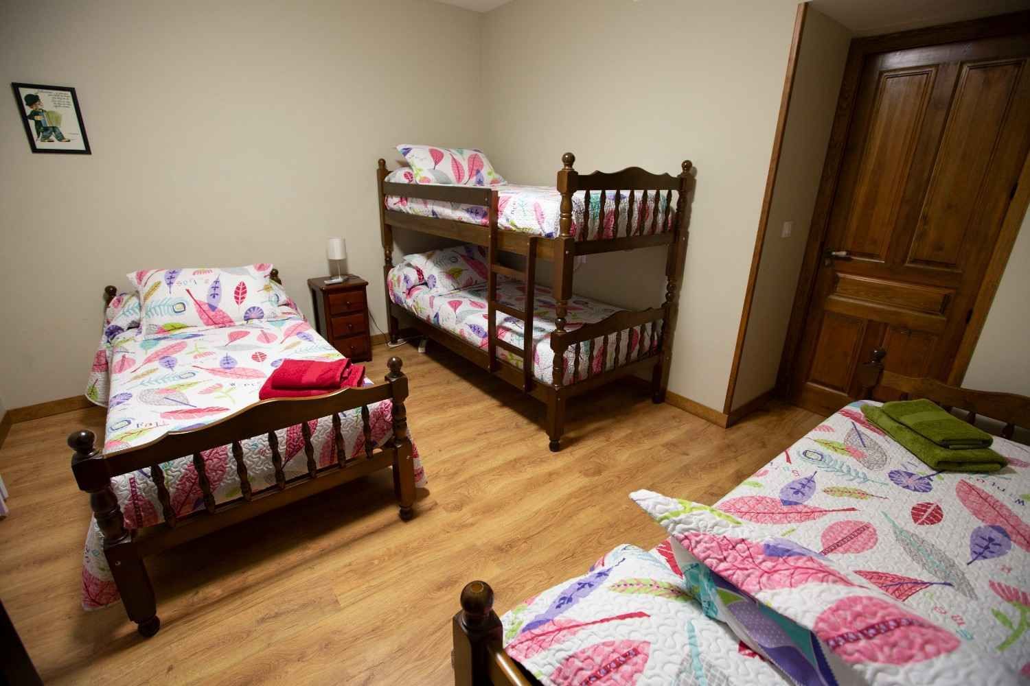 Habitación pequeña con tres camas de madera