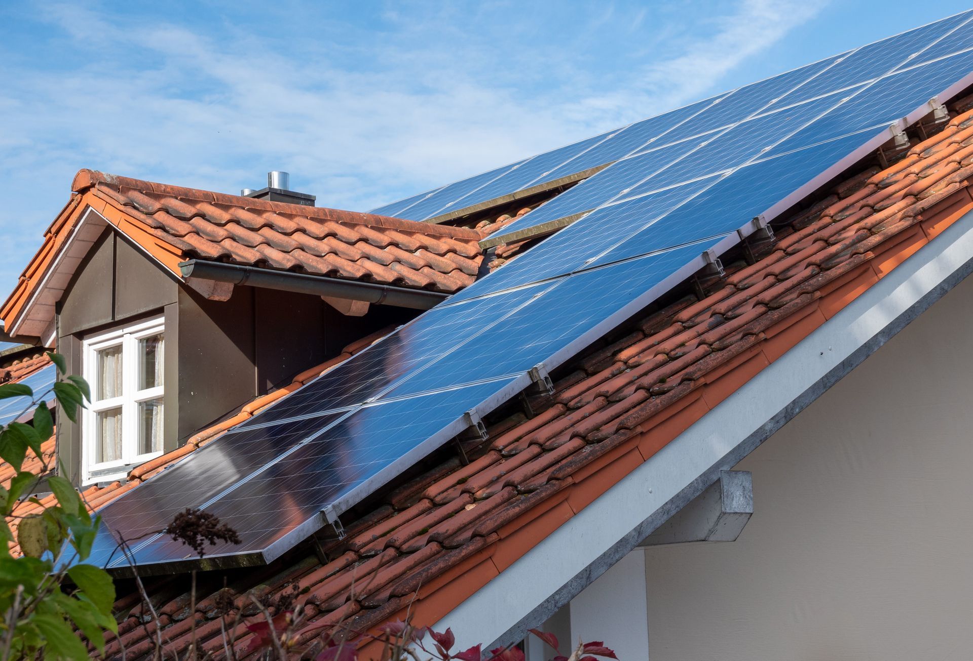 Una fila de paneles solares en el tejado de una casa.