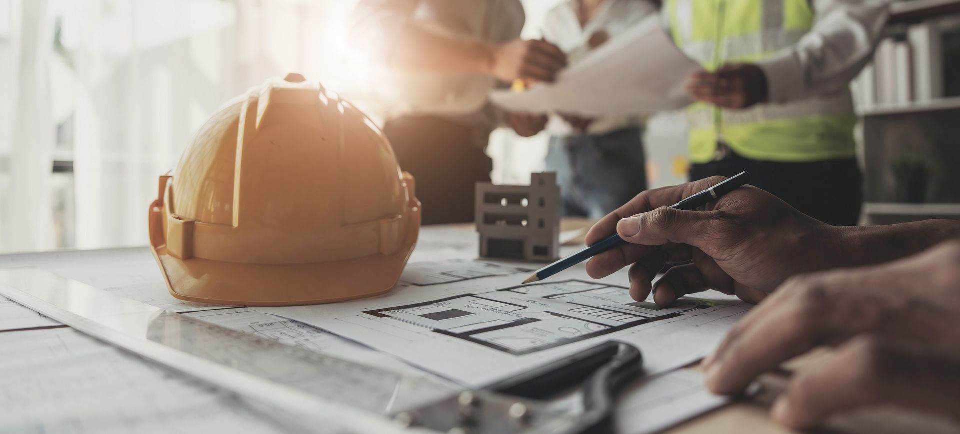 Un grupo de trabajadores de la construcción está mirando un plano en una mesa.
