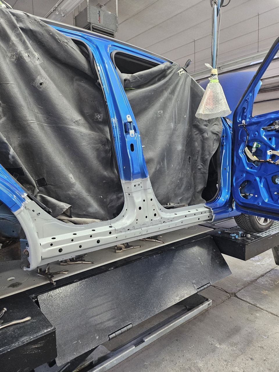 Reparaturvorgang am blauen Fahrzeug