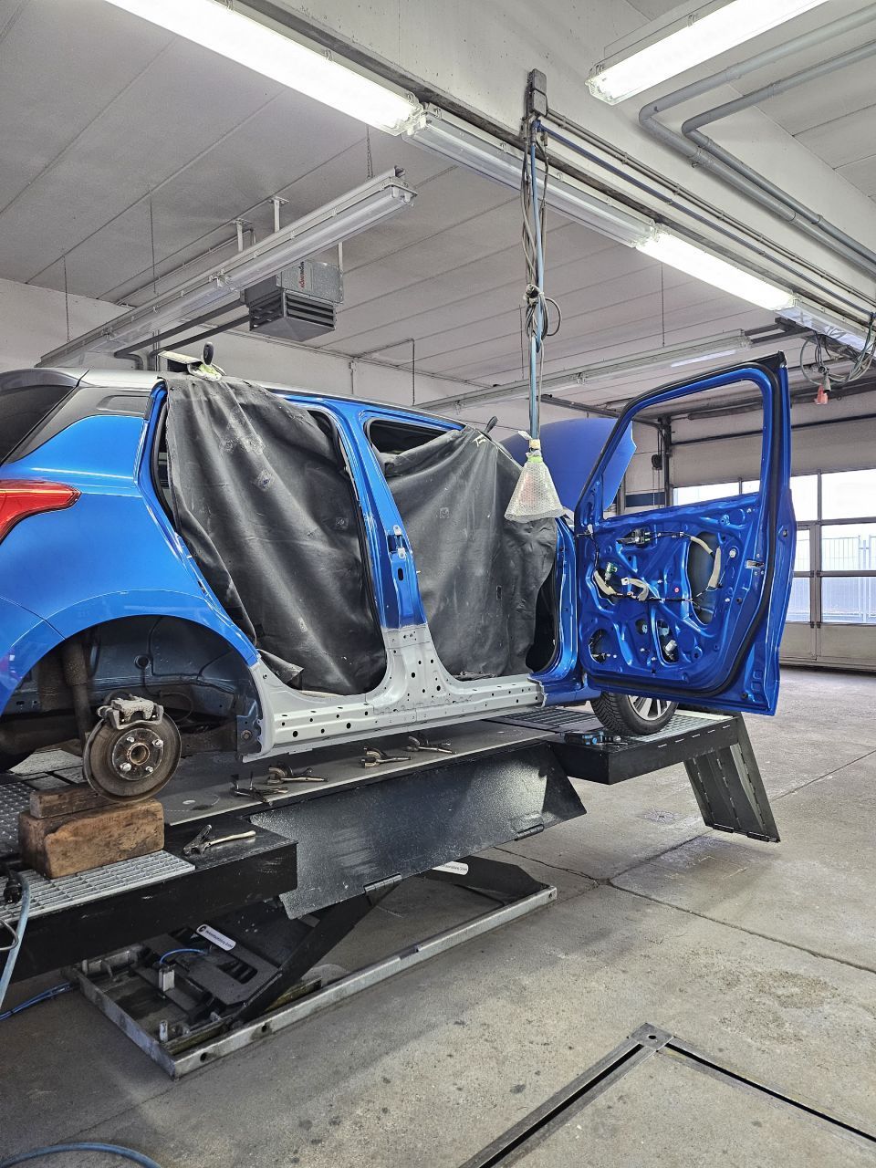 Reparaturvorgang am blauen Fahrzeug