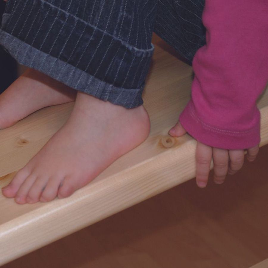 Kind sitzt auf einem Brett