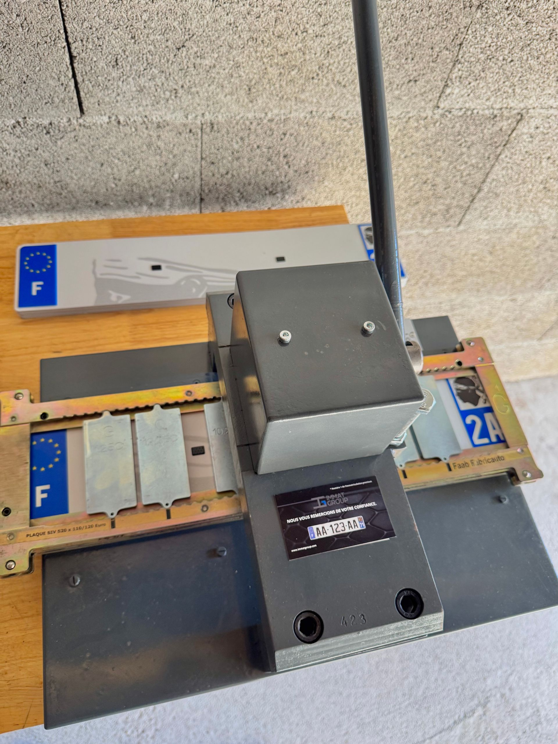 Machine de marquage de plaques d'immatriculation avec écran et plaque d'immatriculation française.