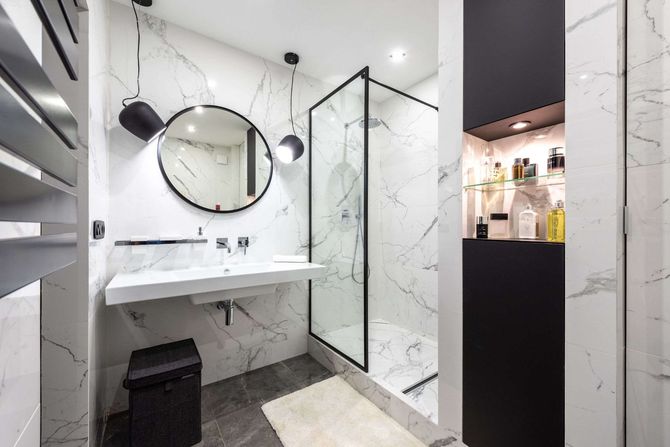 Un baño con lavabo, espejo y ducha.