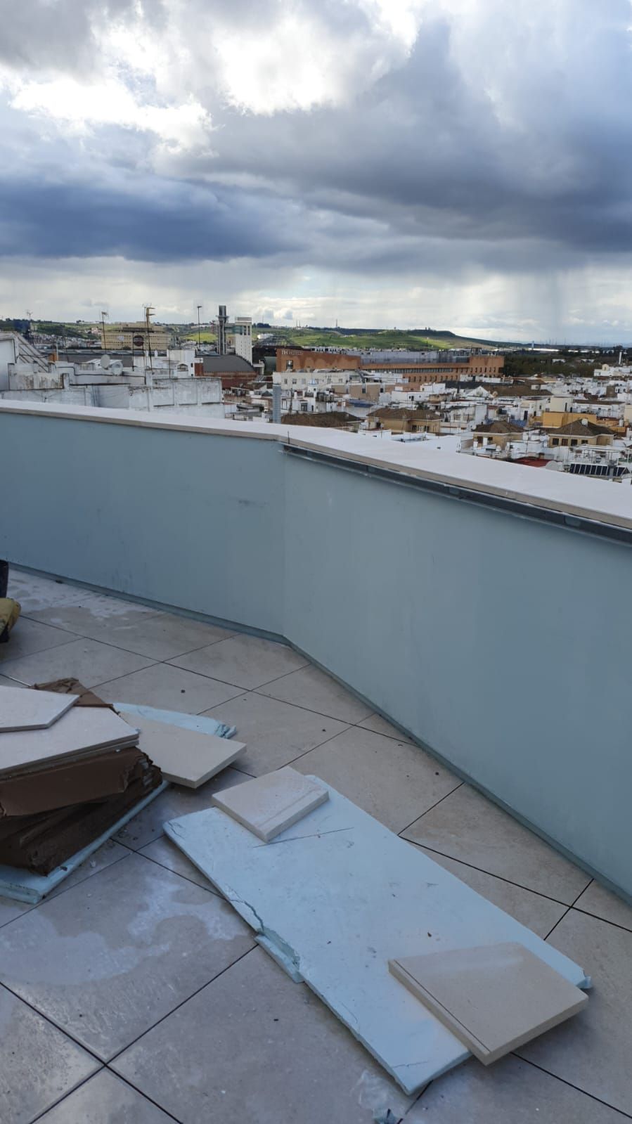 Una azotea con vista a una ciudad y algunos trozos de madera sobre ella.