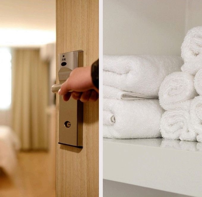 Una mano abriendo la puerta de una habitación de hotel; toallas blancas y esponjosas están apiladas en un estante.