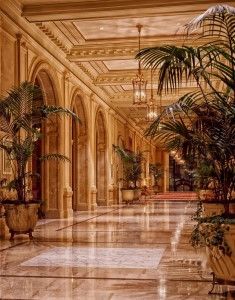 Una fregona limpia un suelo de baldosas marrones y brillantes en un pasillo con una iluminación suave.