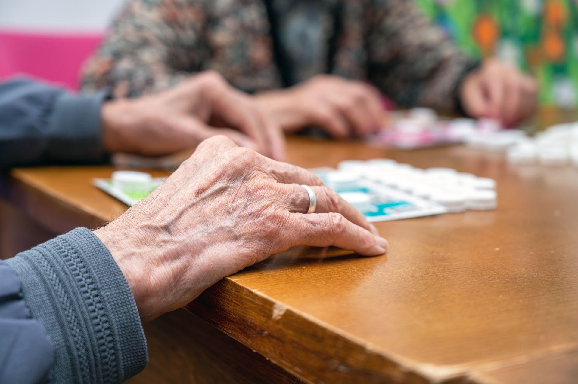 Un grupo de personas está sentada en una mesa jugando una partida de dominó.