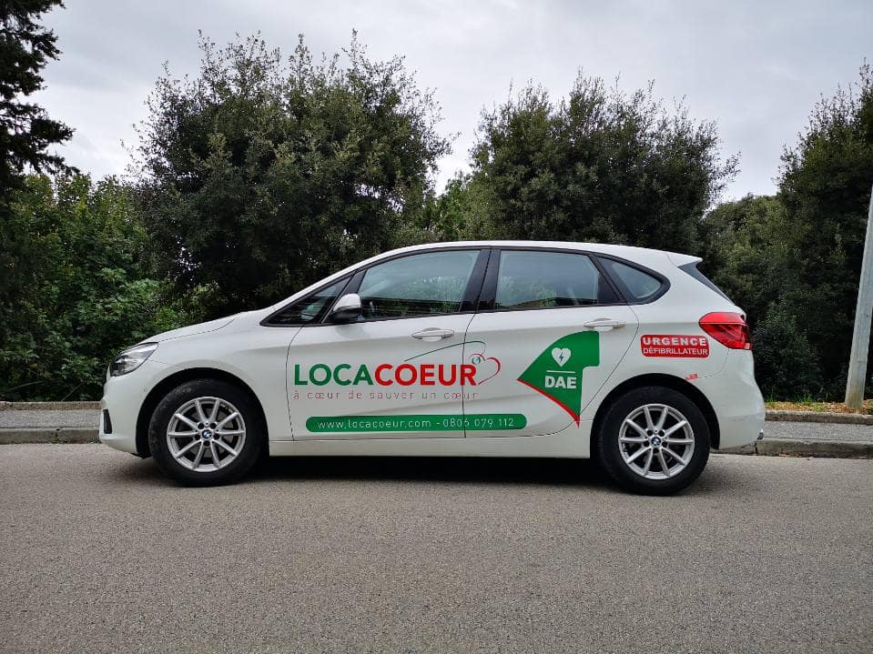 Utilisation d'un lettrage adhésif vert et rouge sur une voiture blanche pour l'entreprise LOCACOEUR