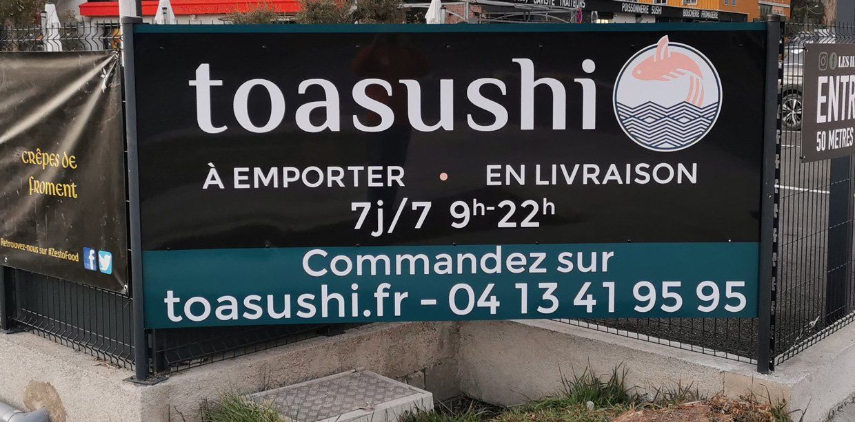 Panneau publicitaire fond noir et bleu pour le restaurant Toasushi
