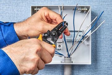 Elektrofachmann arbeitet an Kabeln