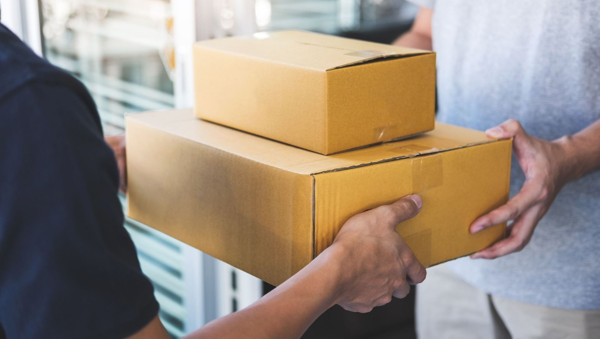 Una persona le está entregando una caja de cartón a otra persona.