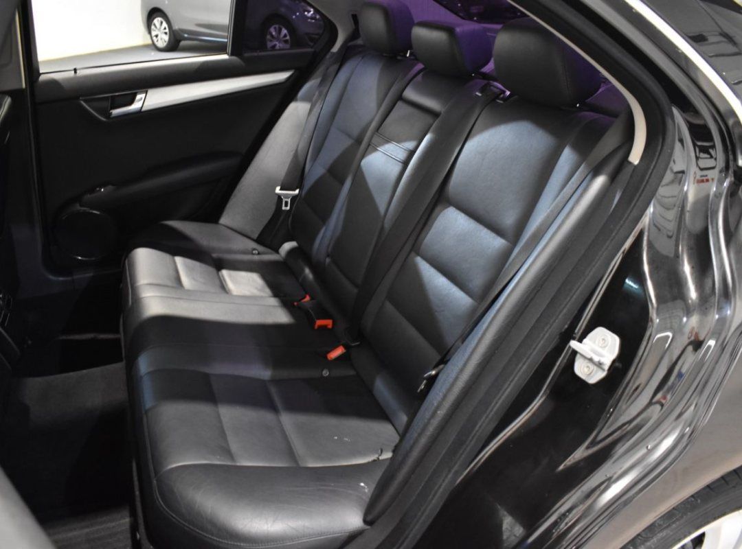 Se muestran los asientos traseros de un coche negro.