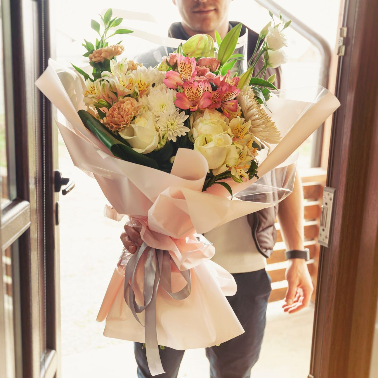 Un livreur tend un bouquet de fleurs