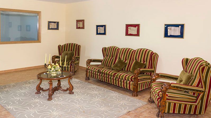 Una sala de estar con un sofá, sillas y una mesa de café.