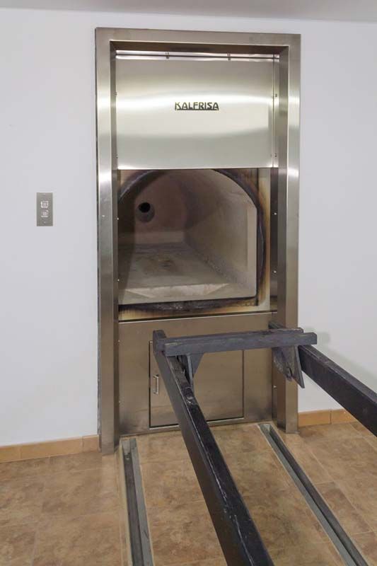 Un horno de acero inoxidable está en una habitación al lado de una puerta.