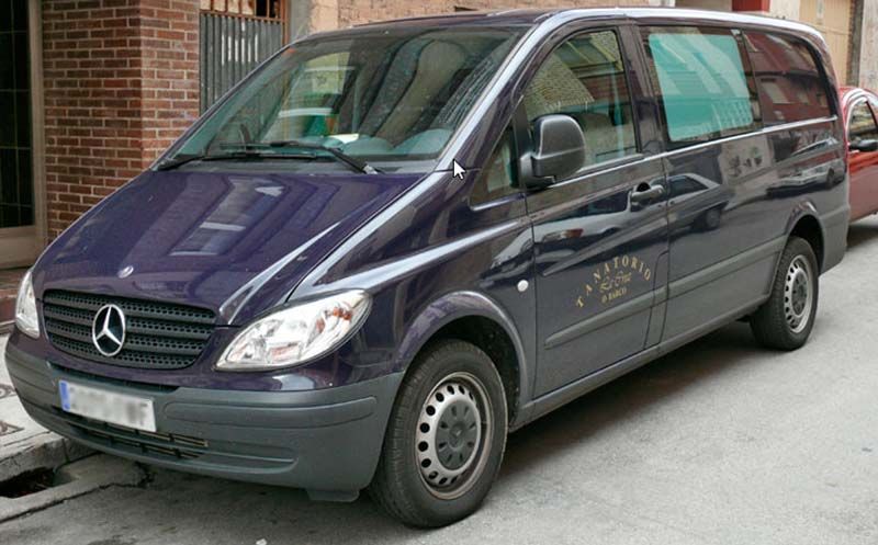 Una furgoneta Mercedes está estacionada al costado de la carretera.