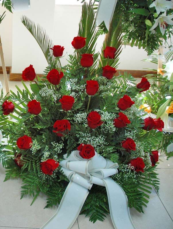 Un ramo de rosas rojas con una cinta blanca