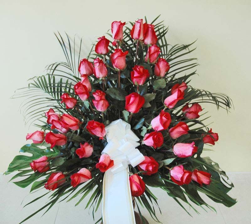 Un ramo de rosas rojas con un lazo blanco