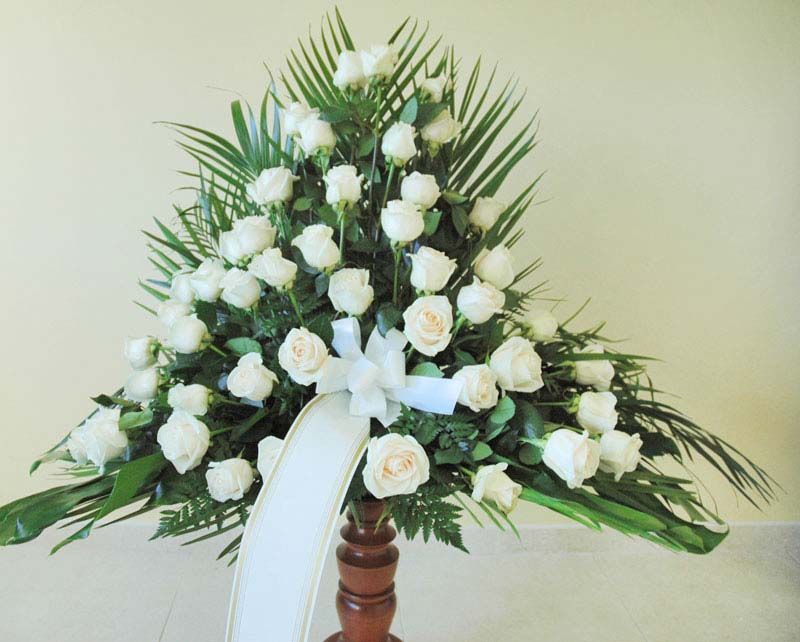 Un ramo de rosas blancas con una cinta blanca