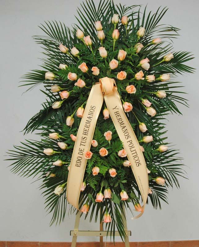 Una corona de flores con una cinta que dice