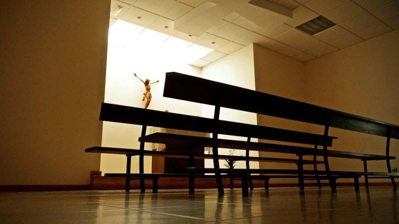 Una iglesia con una estatua de Jesús en la pared.