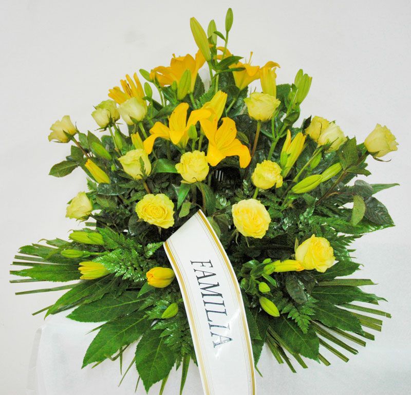Un ramo de flores amarillas con una cinta que dice familia