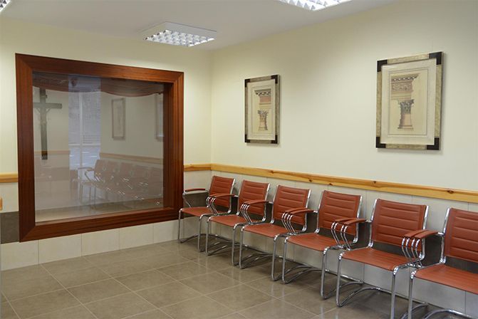 Una sala de espera con sillas y una gran ventana.