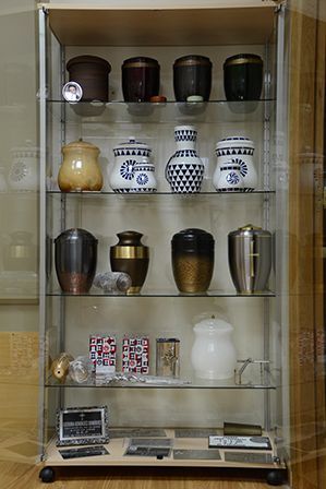 Una vitrina de cristal llena de urnas y jarrones.