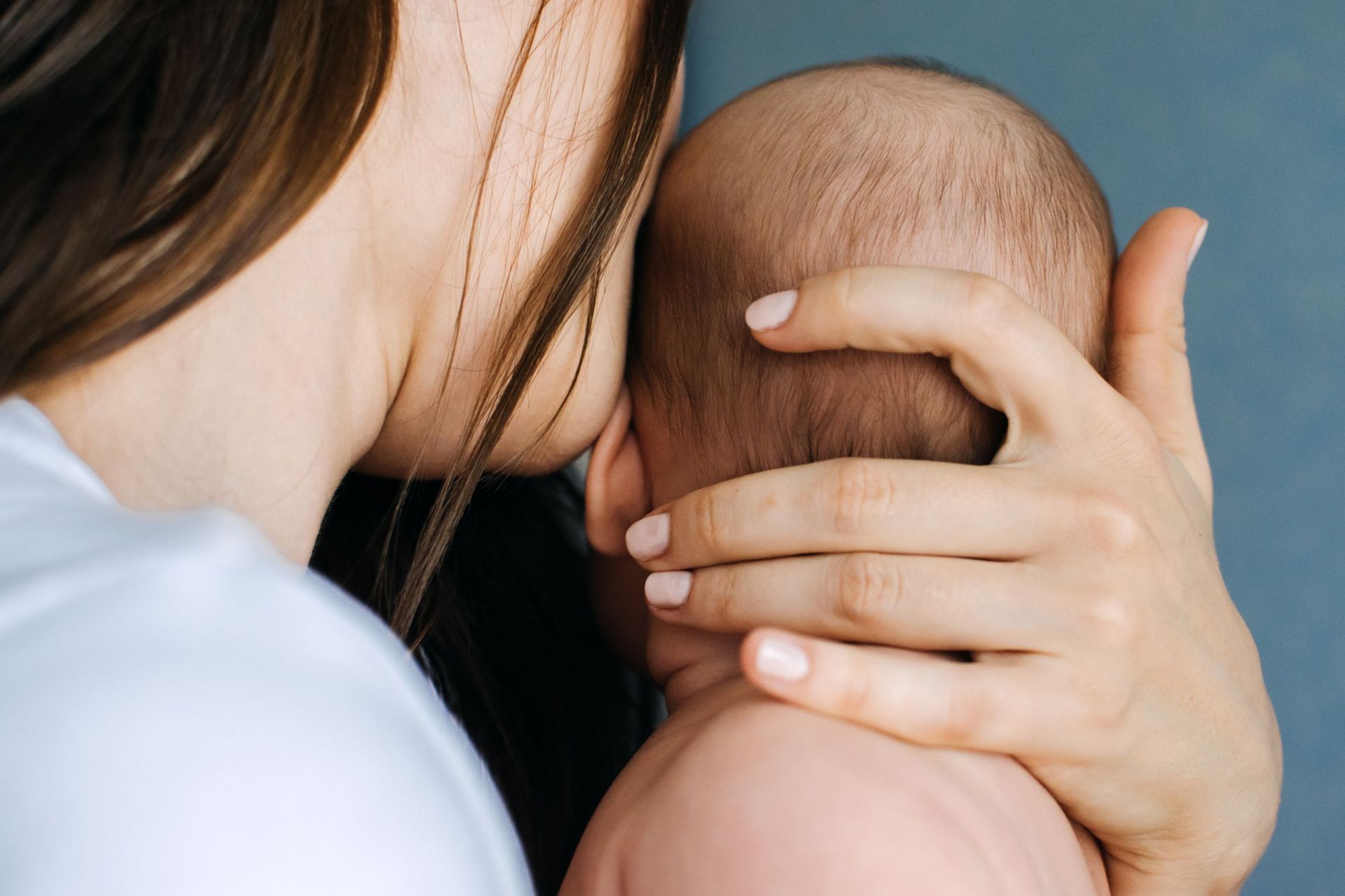 Madre sujetando cabeza de bebé