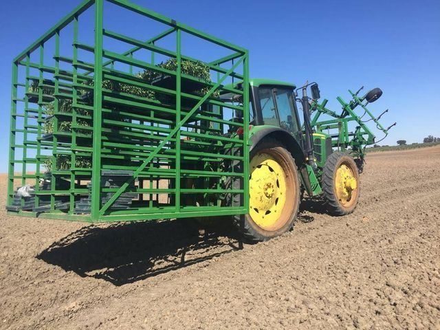 Un tractor verde con un remolque lleno de heno