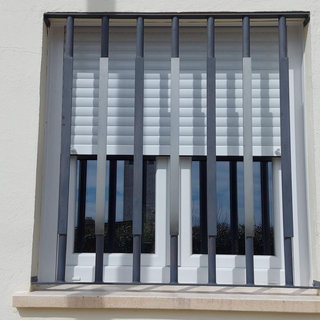 Una ventana con una valla metálica alrededor.