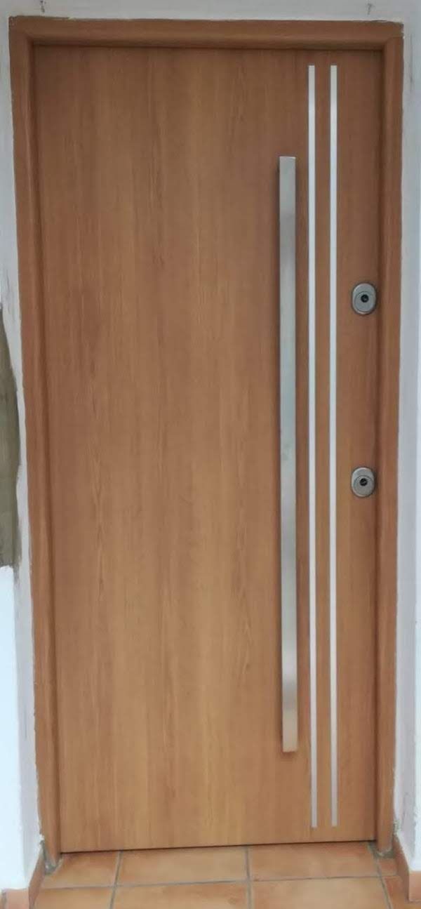 Una puerta de madera con manija de acero inoxidable