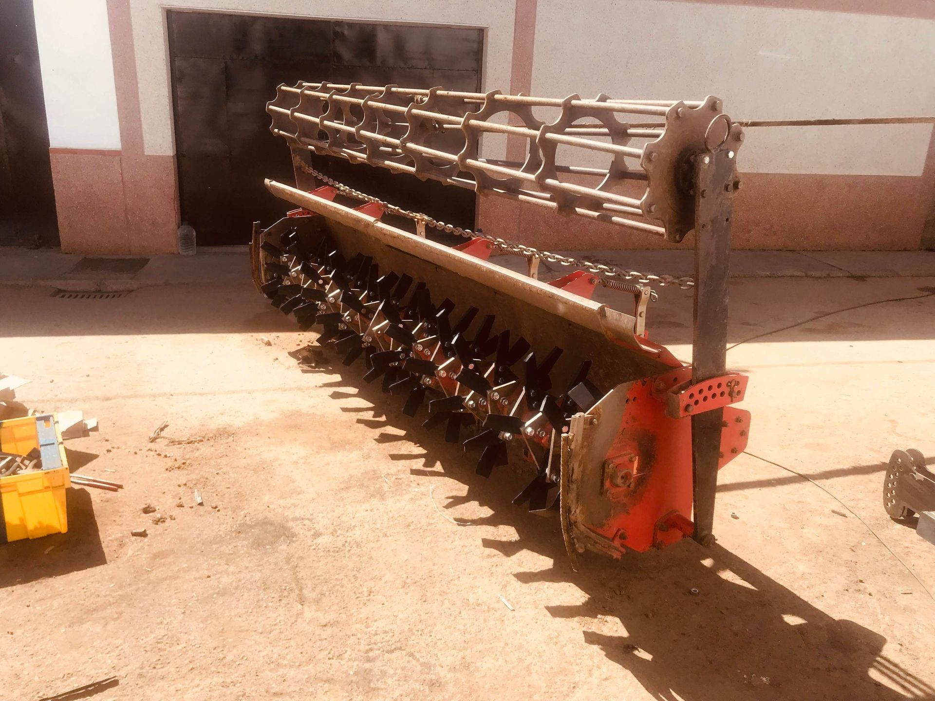 Un tractor grande está estacionado frente a un edificio.
