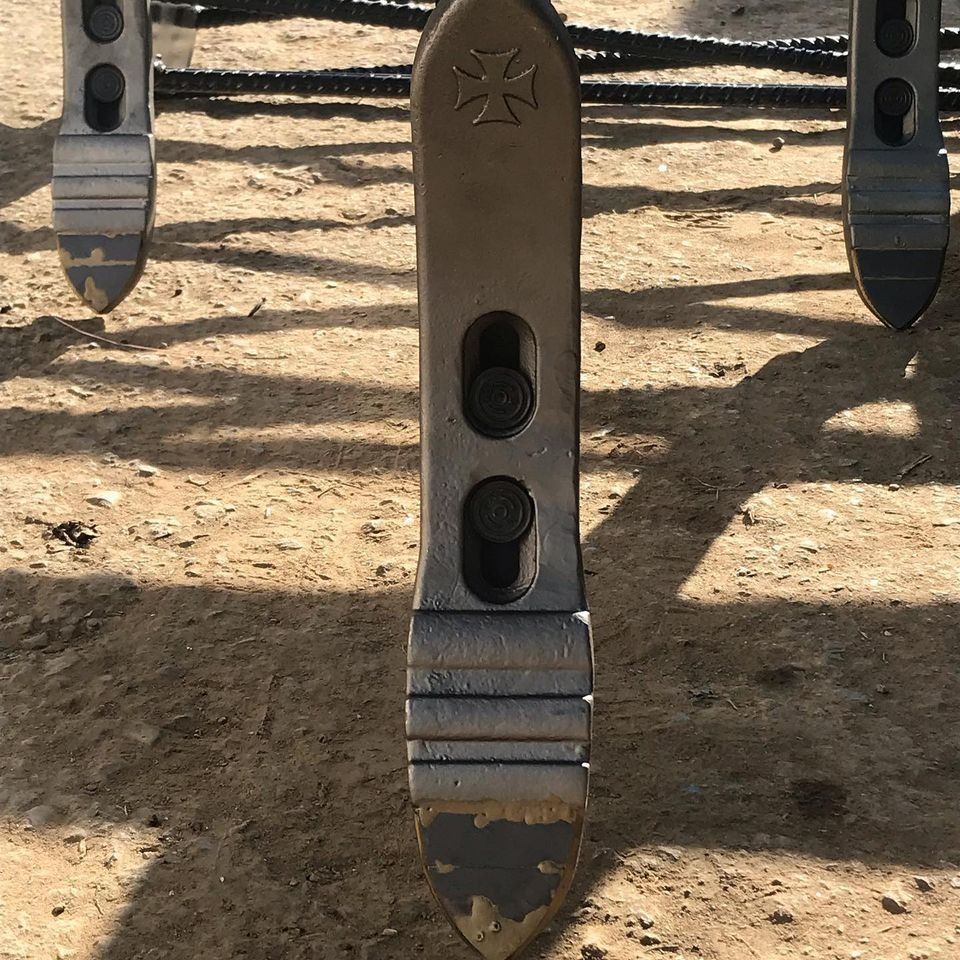 Un primer plano de un objeto de metal con una cruz sobre él.