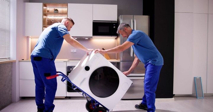 Mitarbeiter der Philippe Kunz GmbH transportieren Waschmaschine