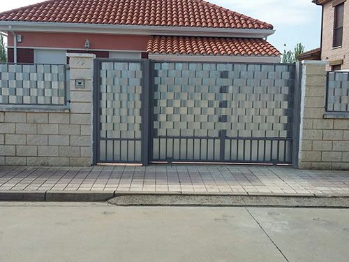 Una casa con una pared de ladrillo y una puerta de metal.