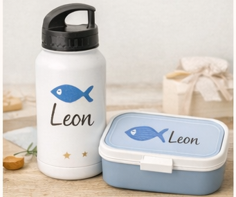 Weiße Wasserflasche und blaue Brotdose, beide mit einem blauen Fischmotiv und dem Namen „Leon“.
