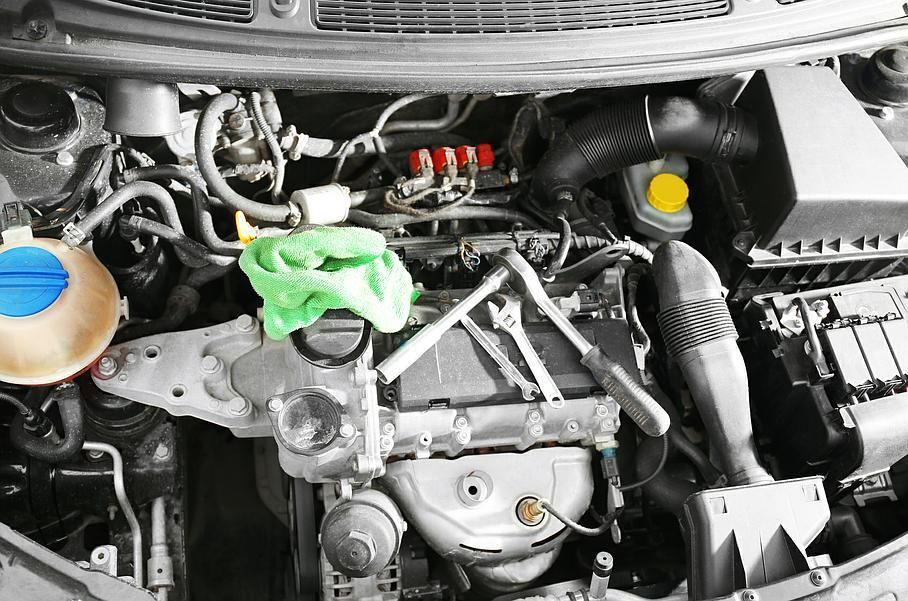 Person prüft ein Auto in einer Werkstatt