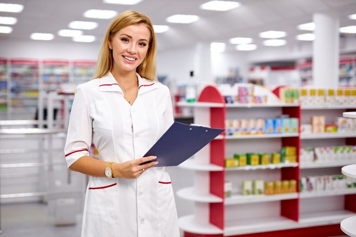 Una farmacéutica sostiene un portapapeles en una farmacia.