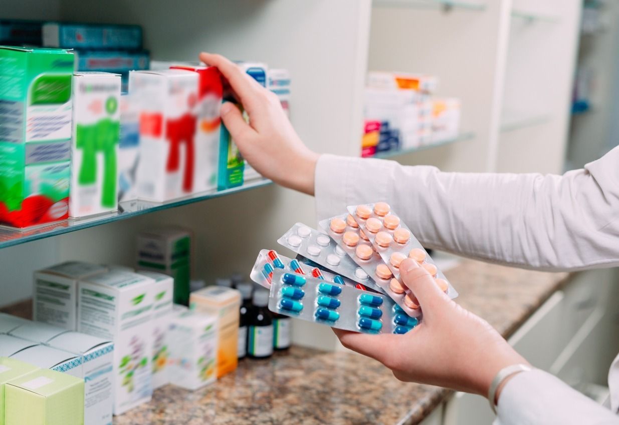 Una farmacéutica sostiene un blíster de pastillas en una farmacia.