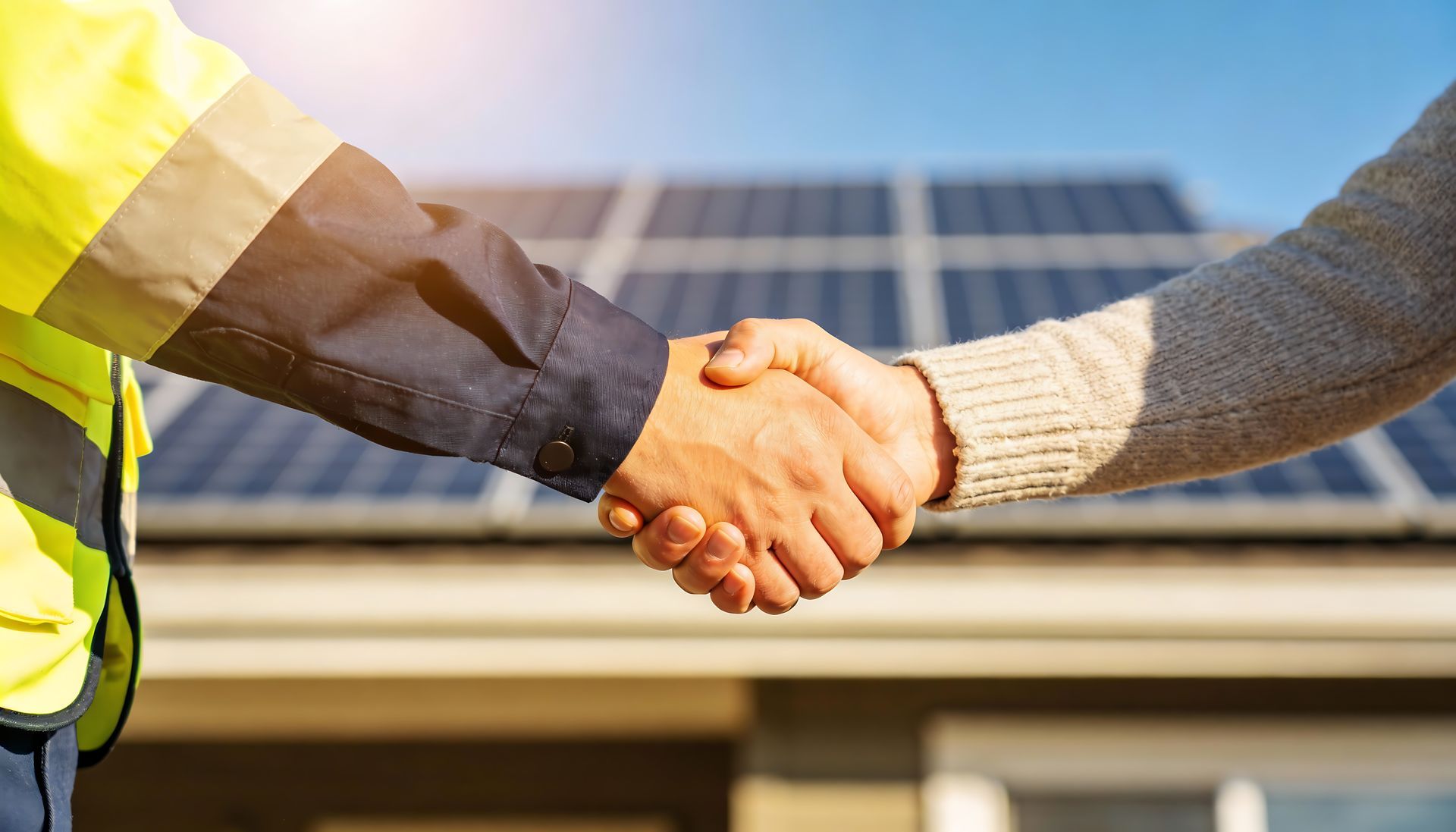 Une poignée de main avec des panneaux solaires en arrière-plan
