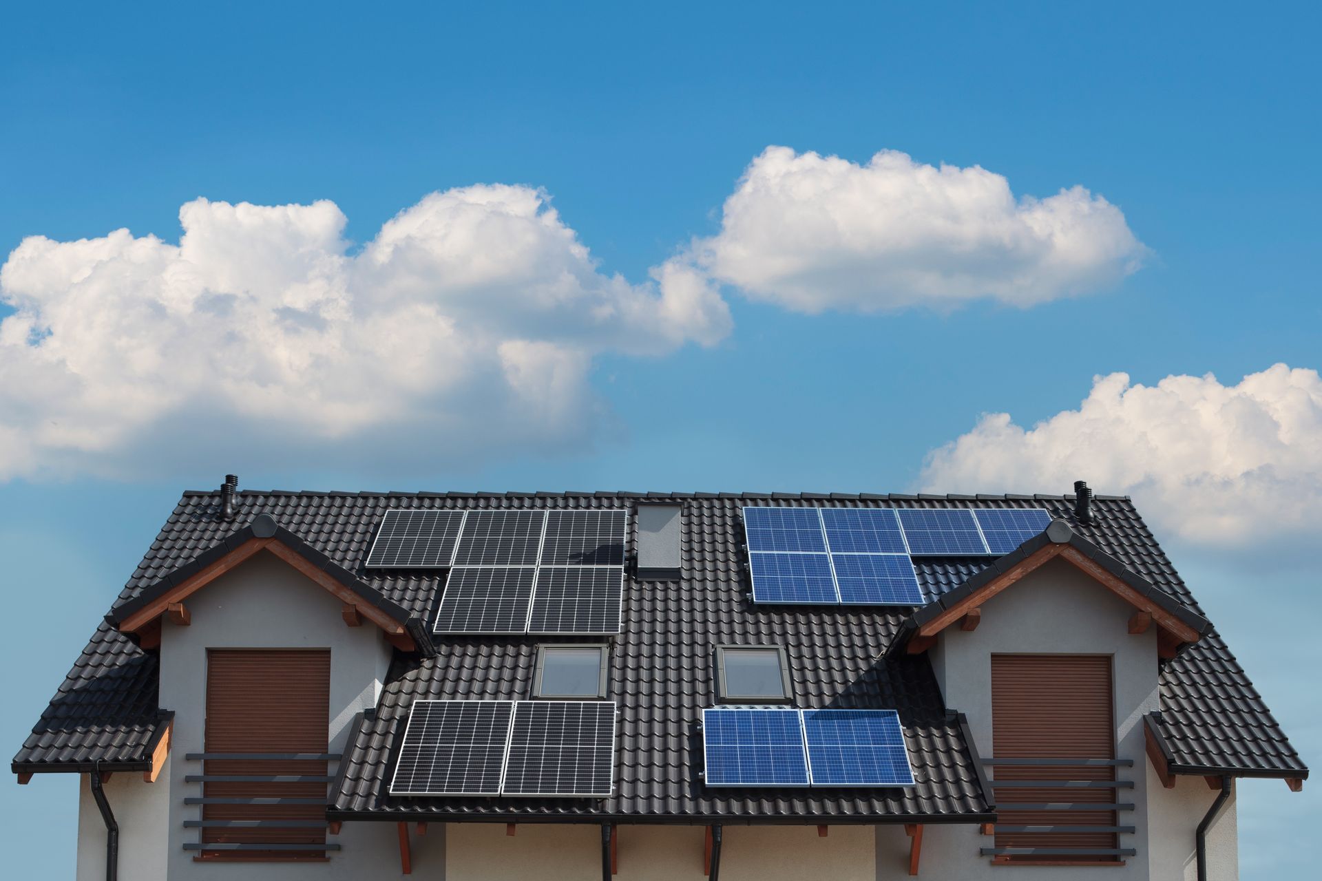 Toiture en tuile qui présente des panneaux solaires bleus et noirs