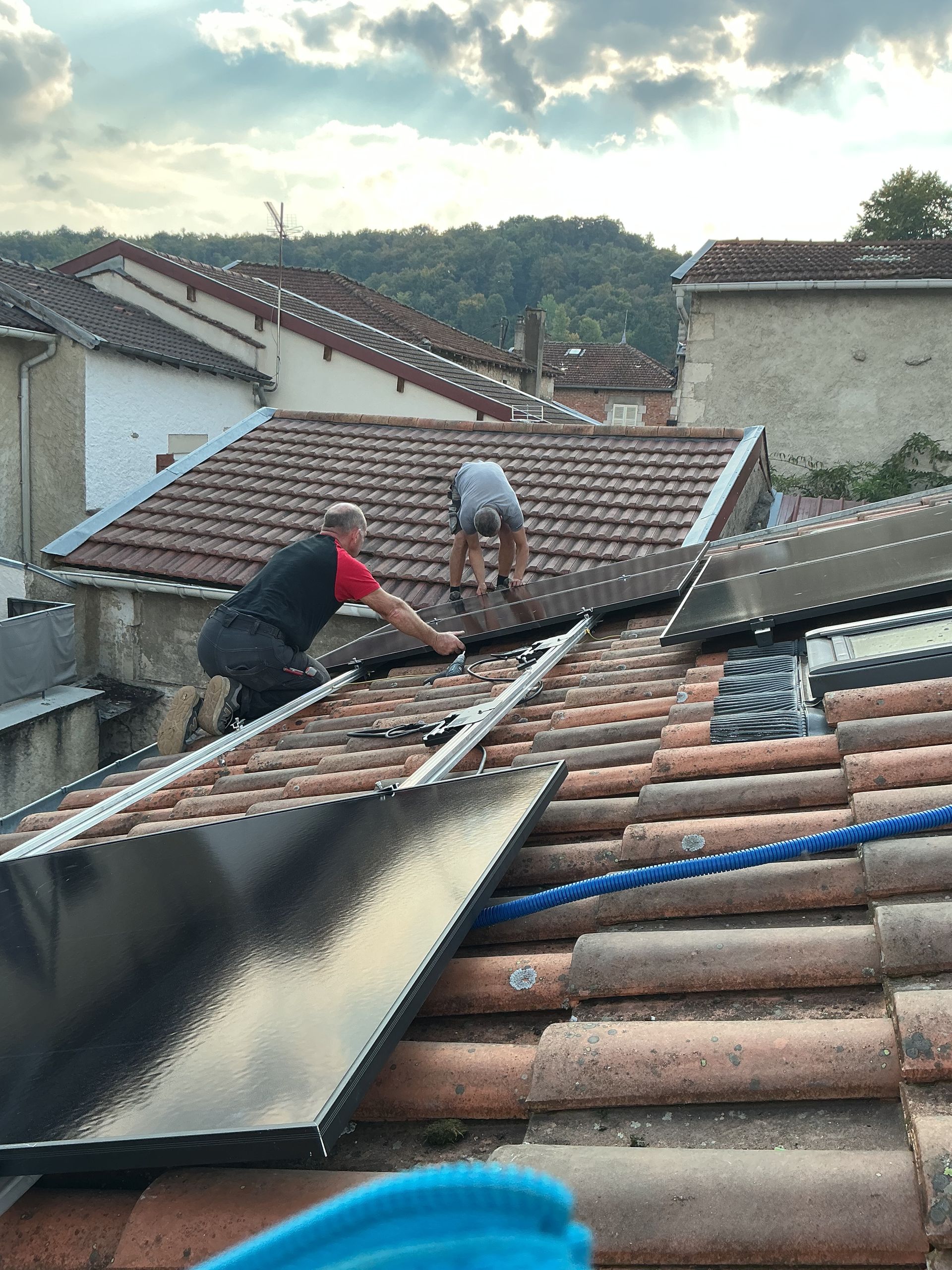 Rails de fixation pour panneaux solaires installés sur un toit, laissant apparaître les micro-onduleurs.