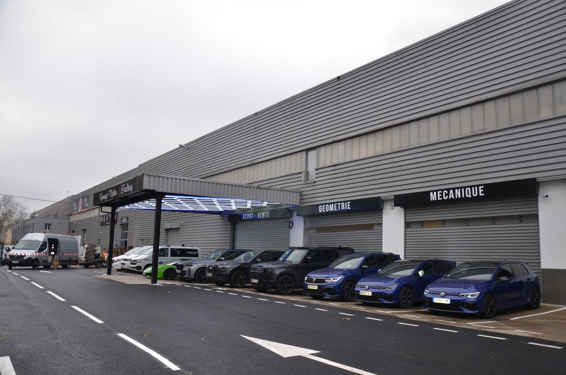 Voitures multimarques stationnées devant le garage