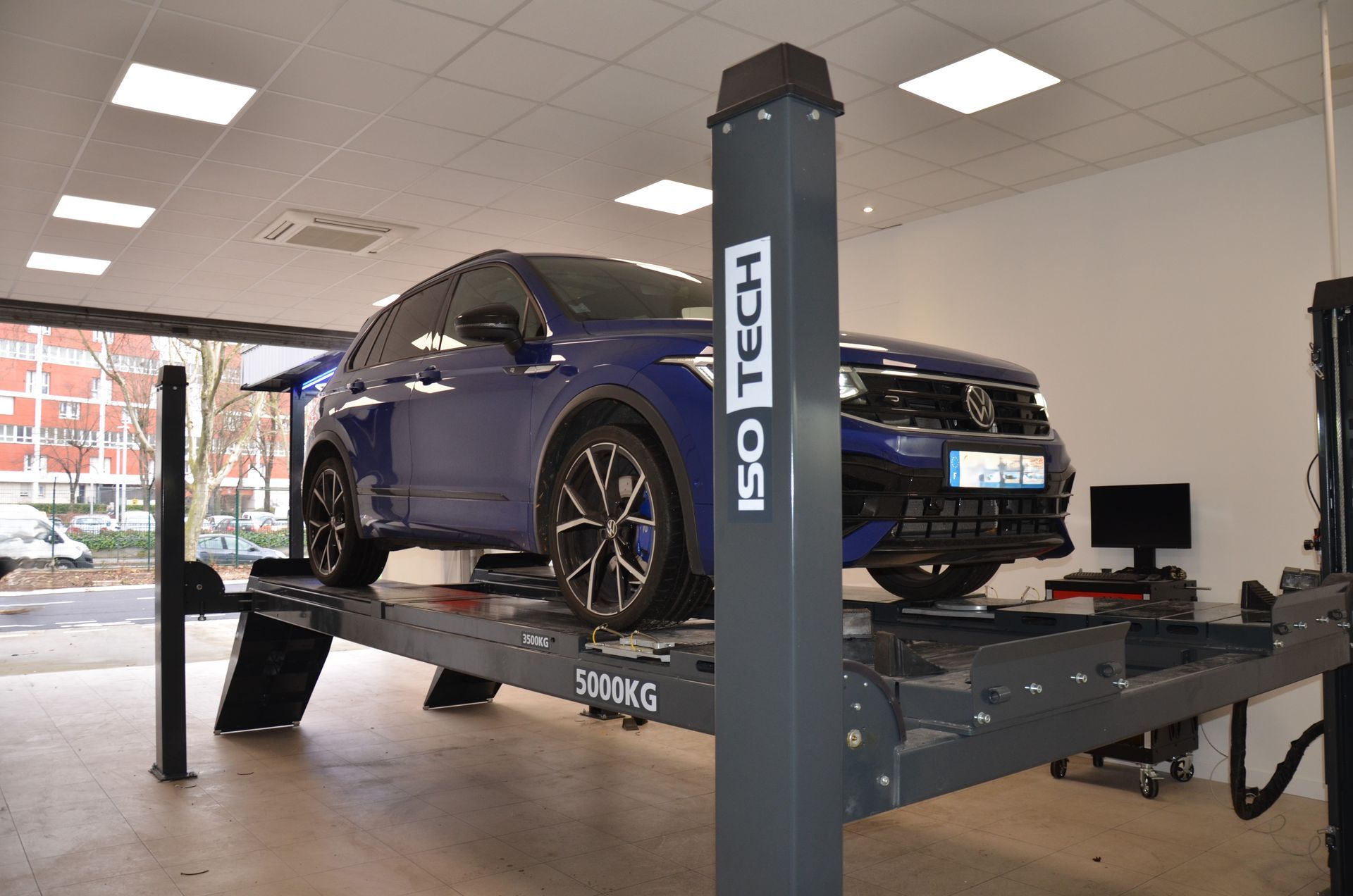 Citadine bleue sur un pont élévateur