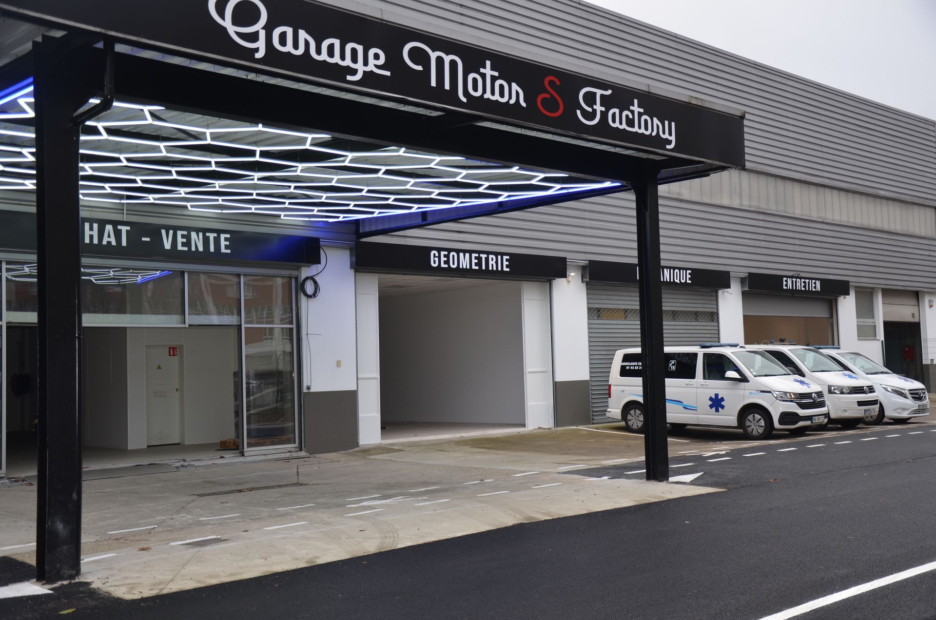 Devanture du garage, véhicule d'ambulance à droite