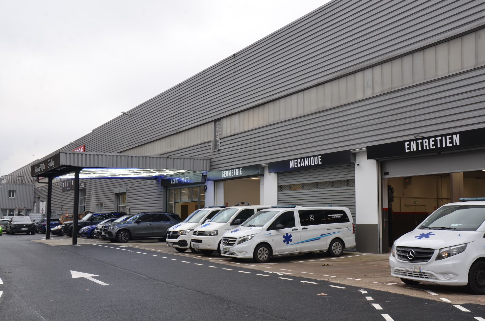 Véhicules devant le garage dont des ambulances