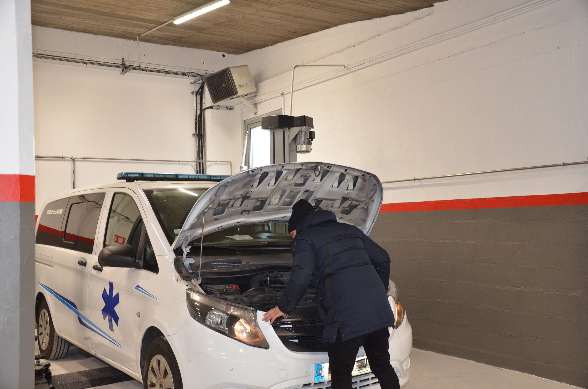 Un mécanicien regarde sous le capot d'une ambulance